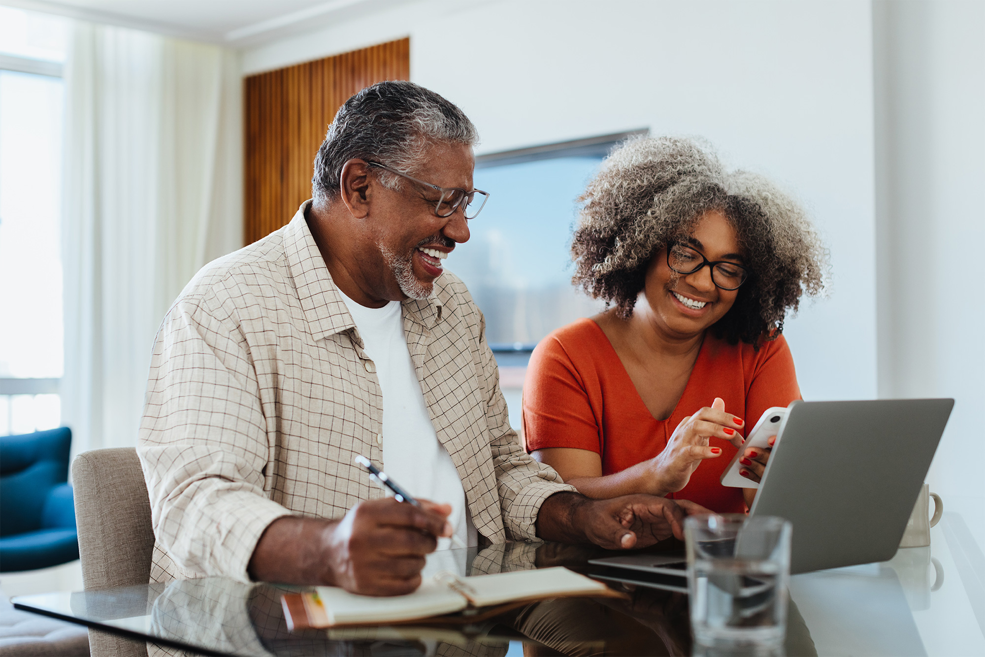 Elderly couple at counter with laptop smiling
