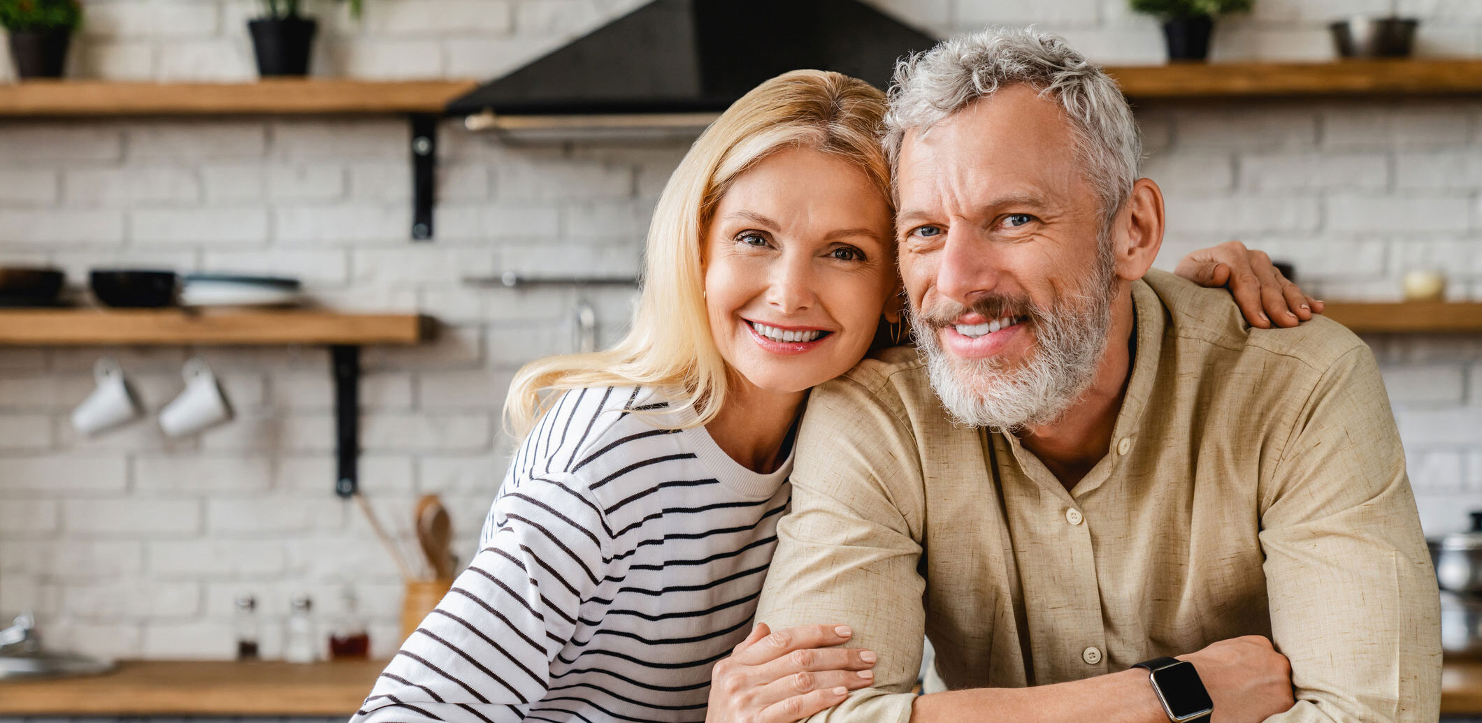 Couple sitting in kitchen smiling