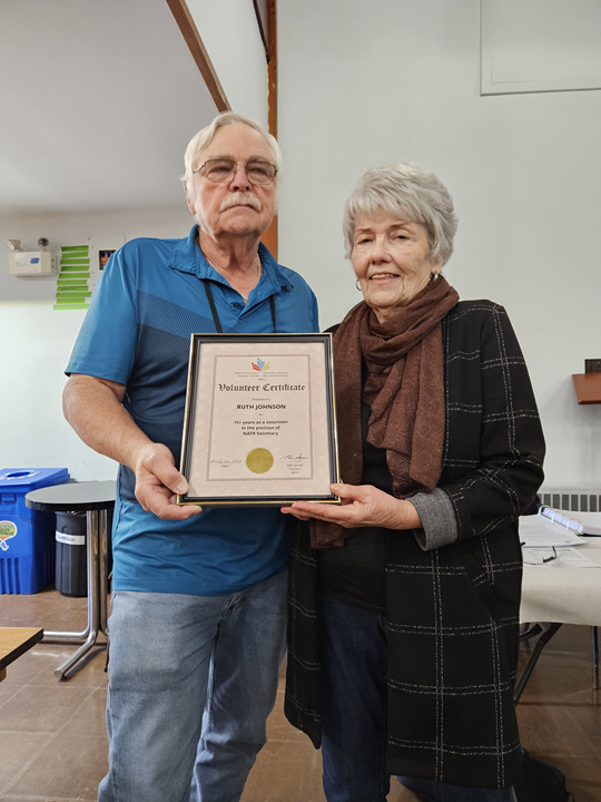 Branch president Glen Jones presenting a certificate of appreciation to Ruth Johnson.
