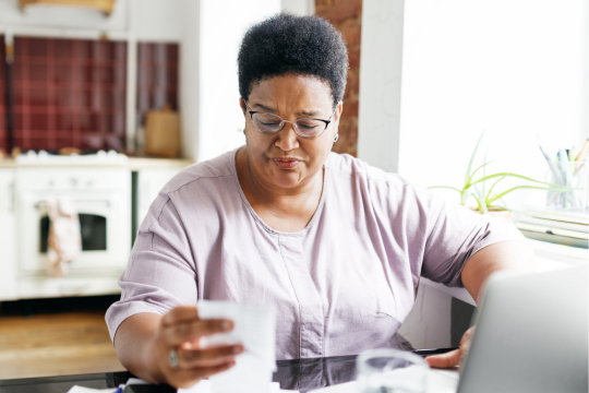 A women can be seen sitting and looking at receipts